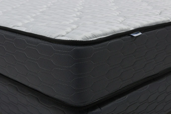 Close-up of a modern mattress with a dark patterned base.